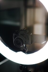 digital photo camera placed on tripod near studio lamp