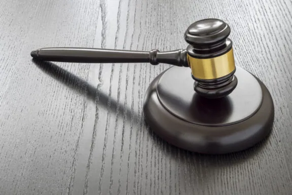 Wood gavel and open handcuffs symbolizing freeing judge decisions